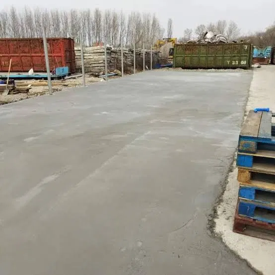Nagy méretű, frissen simított beton lemezalap ipari csarnok területén