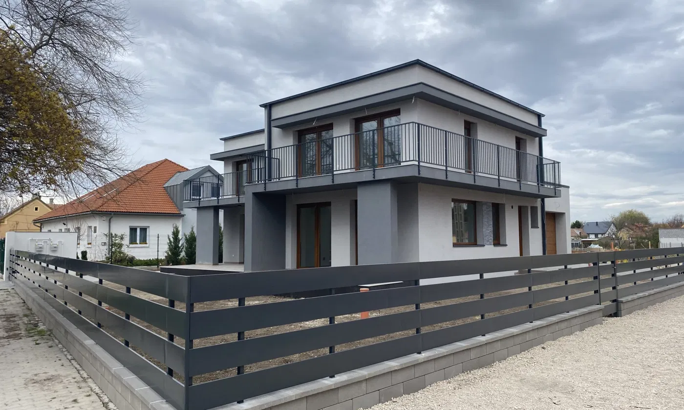 Alapkő Kft. által kivitelezett modern családi ház, kész homlokzattal és kerítéssel
