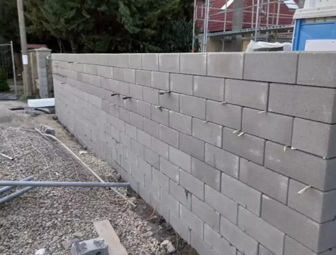 Épülő beton üregestest támfal kerítésalaphoz, kiálló armatúravasakkal